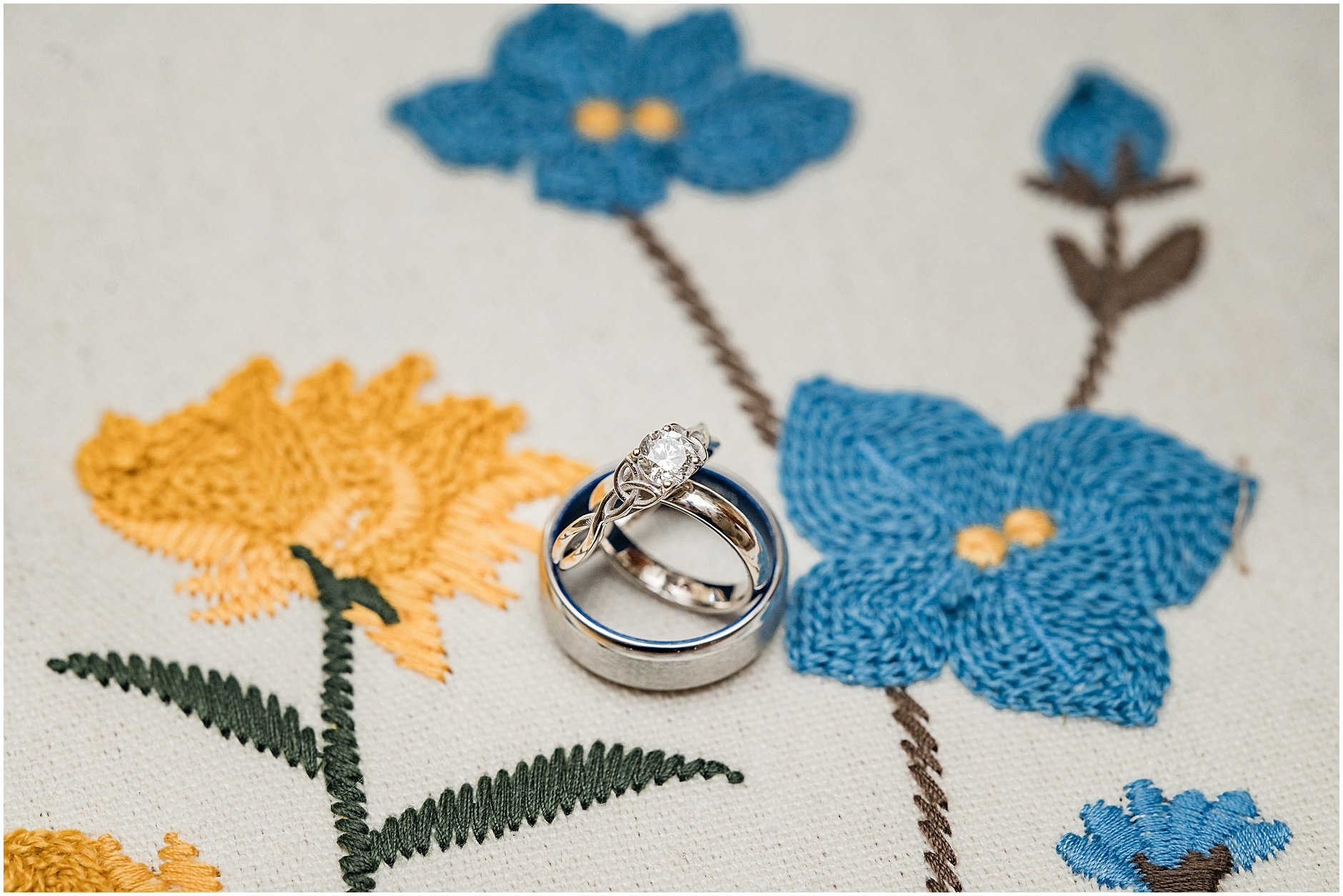 Detail shot of the bride and groom's rings together with florals