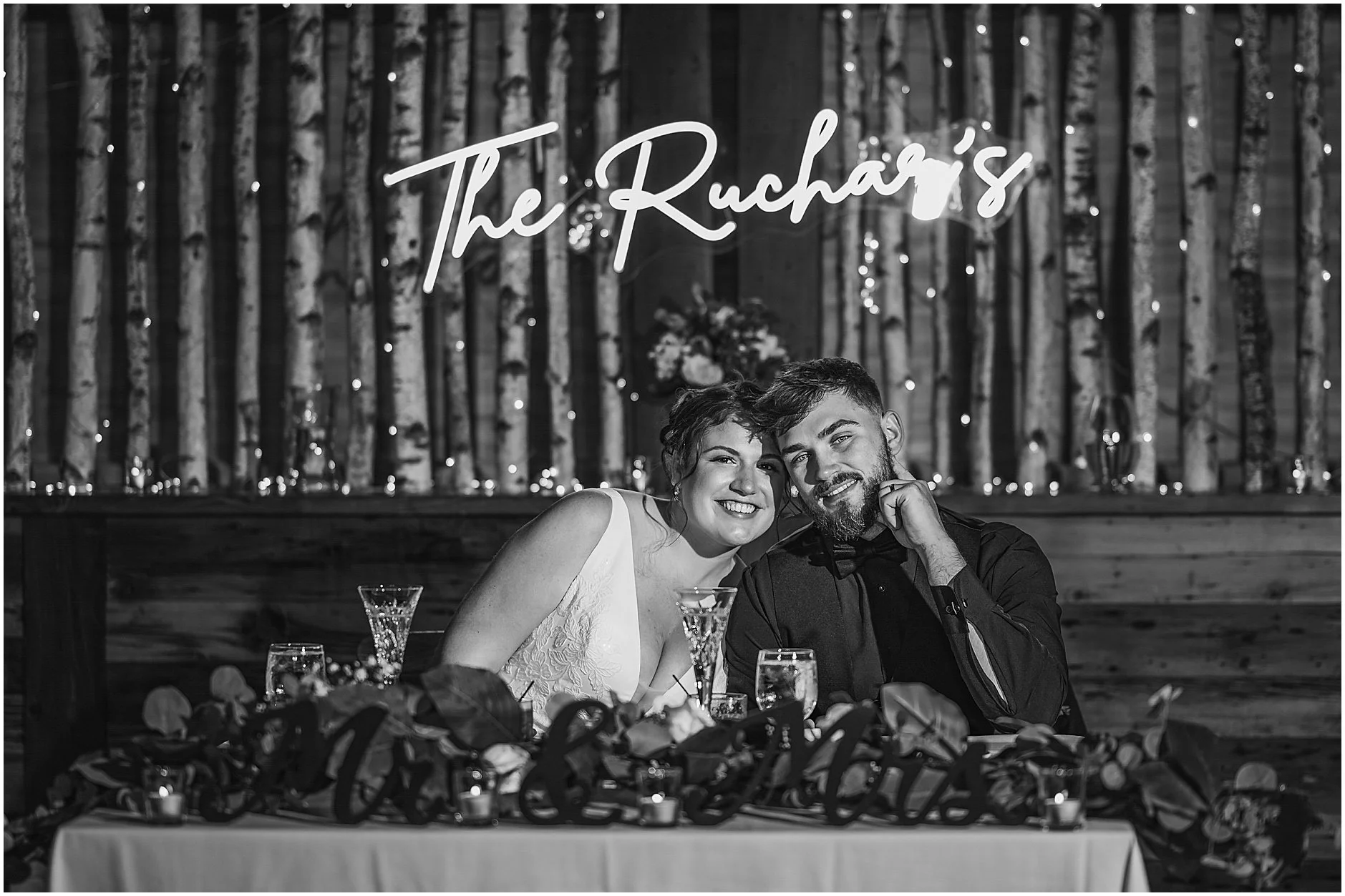 Black and white photo of the bride and groom at their sweetheart table during their Catskill, NY reception.
