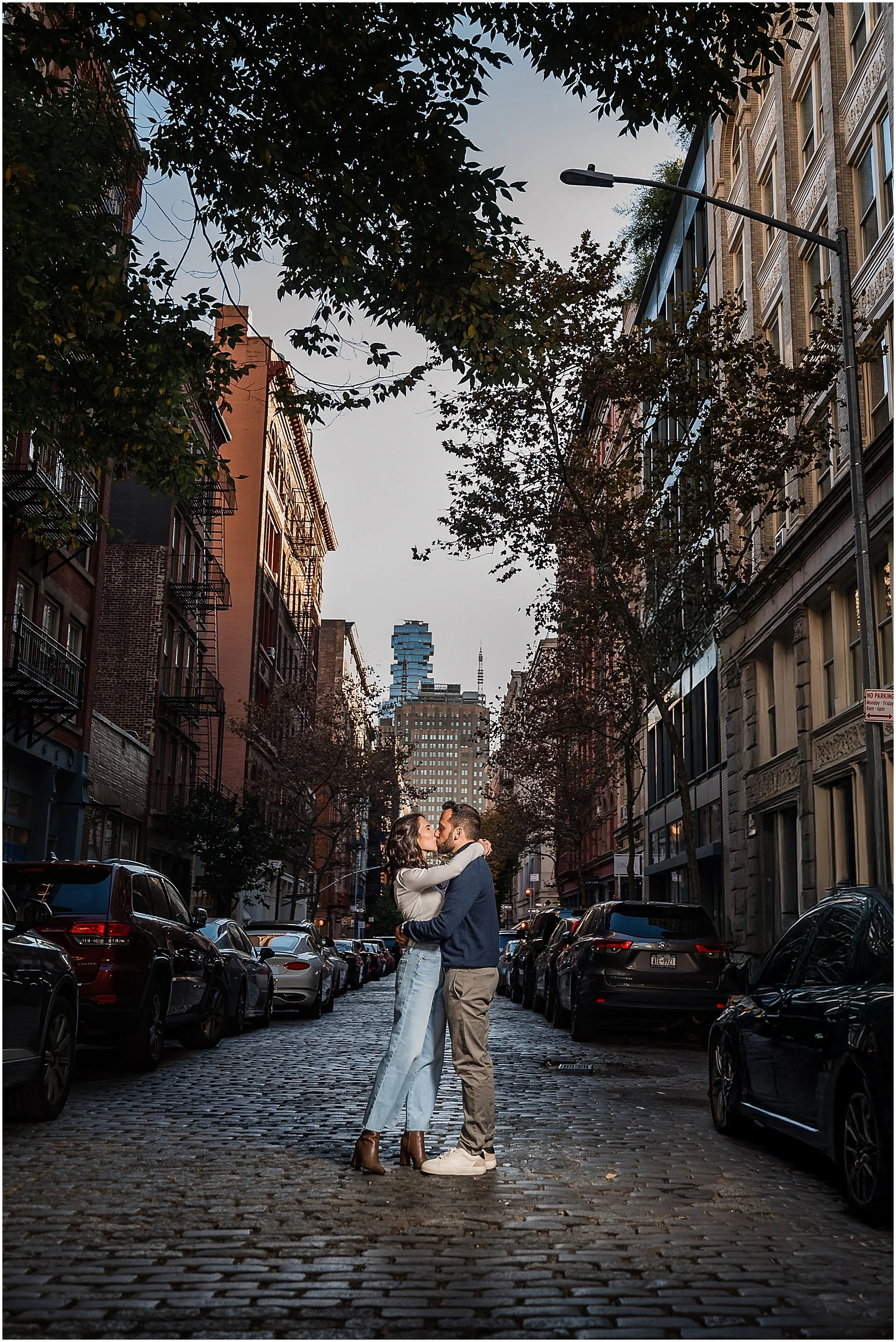 Couple sharing a kiss on cobblestone street in New York City