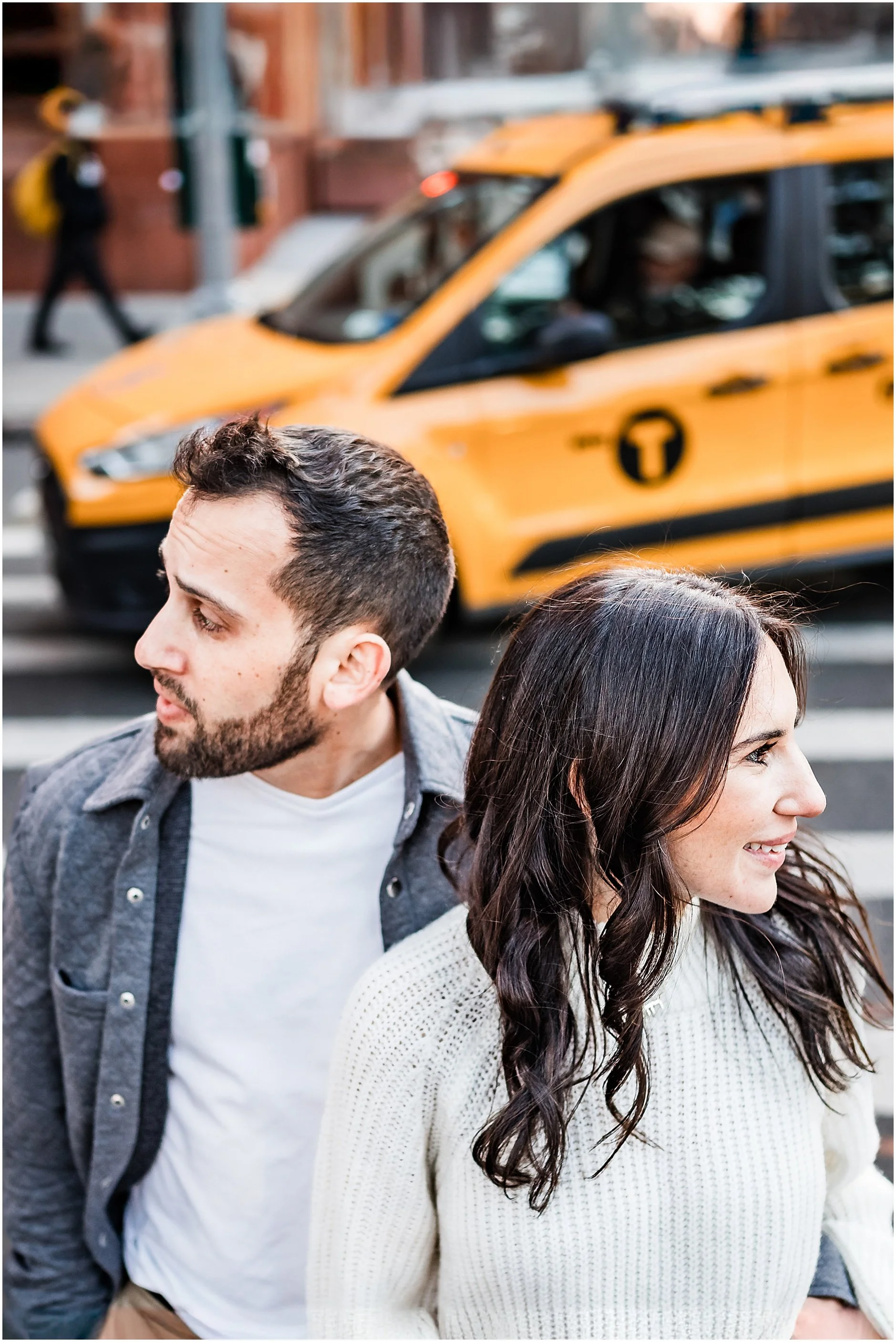 Editorial image of engaged couple in the streets of New York City posing together looking opposite ways
