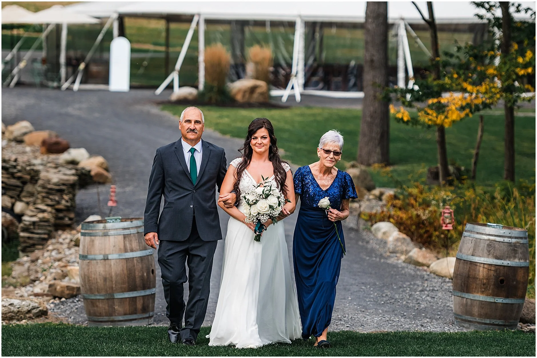 Bride walking down the aisle at The Rosemary at Spano Lake with her parents
