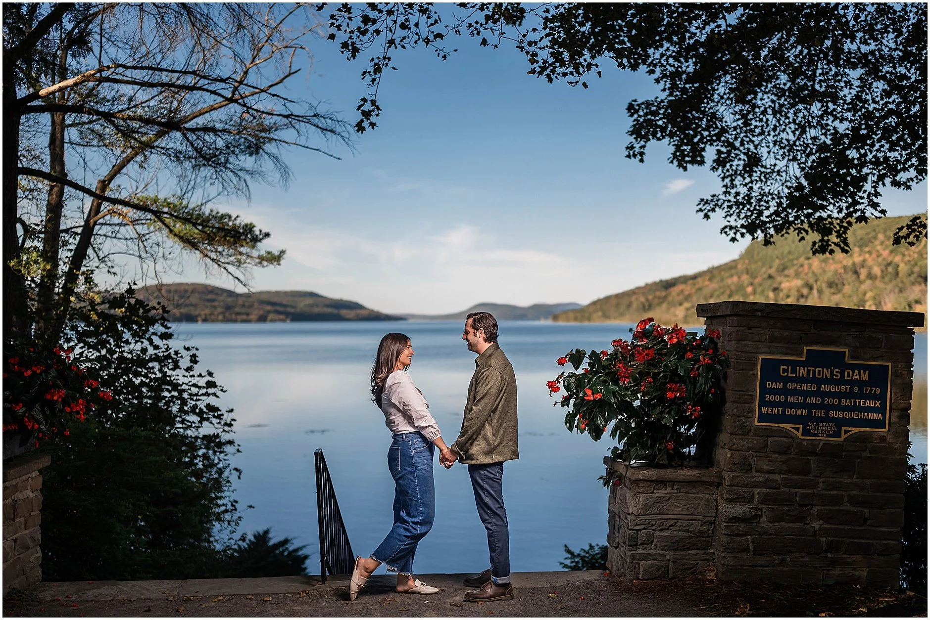 Couple embracing by Otsego Lake during fall engagement session