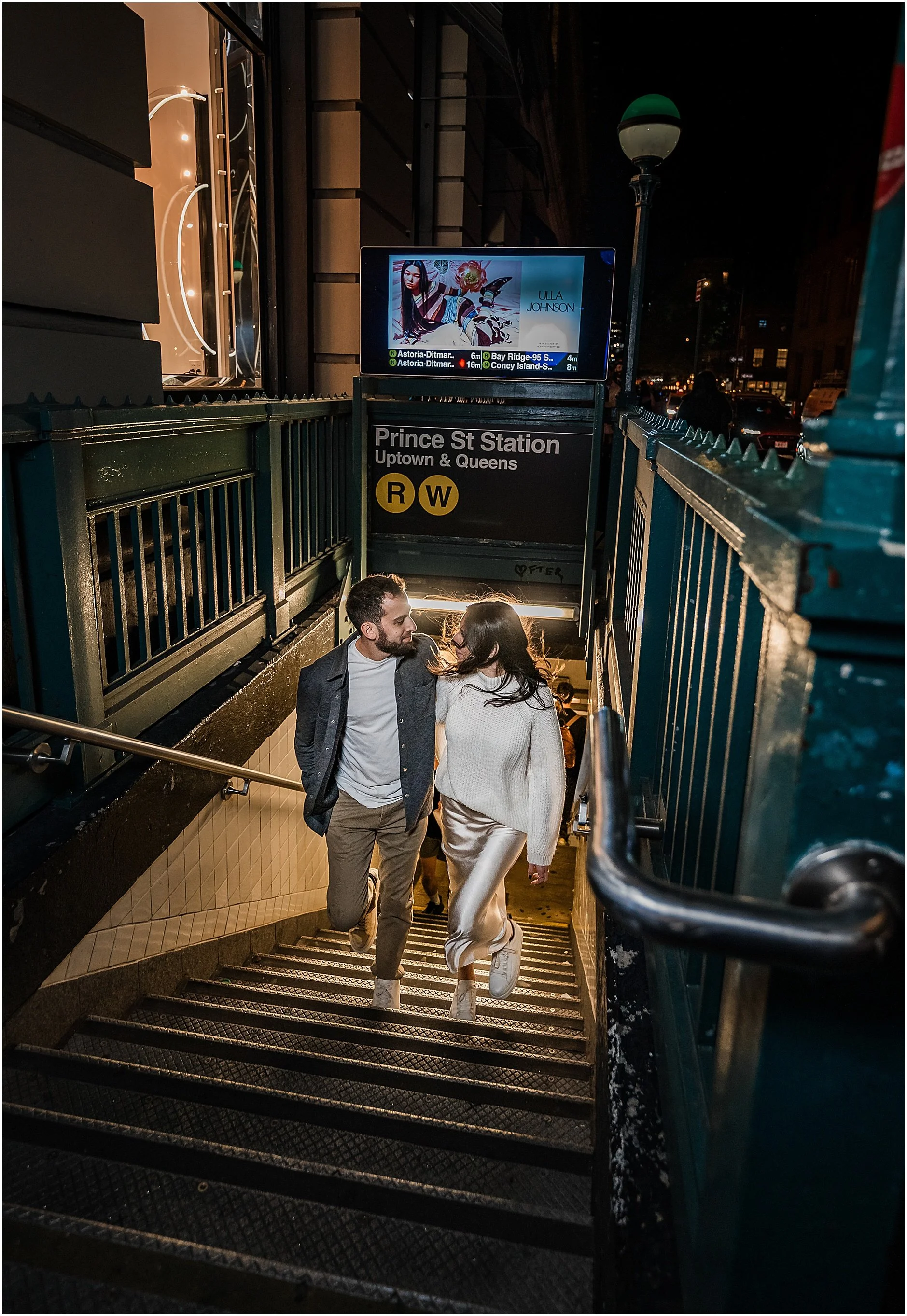 Engagement photos of couple walking up stairs from the subway at night in New York City