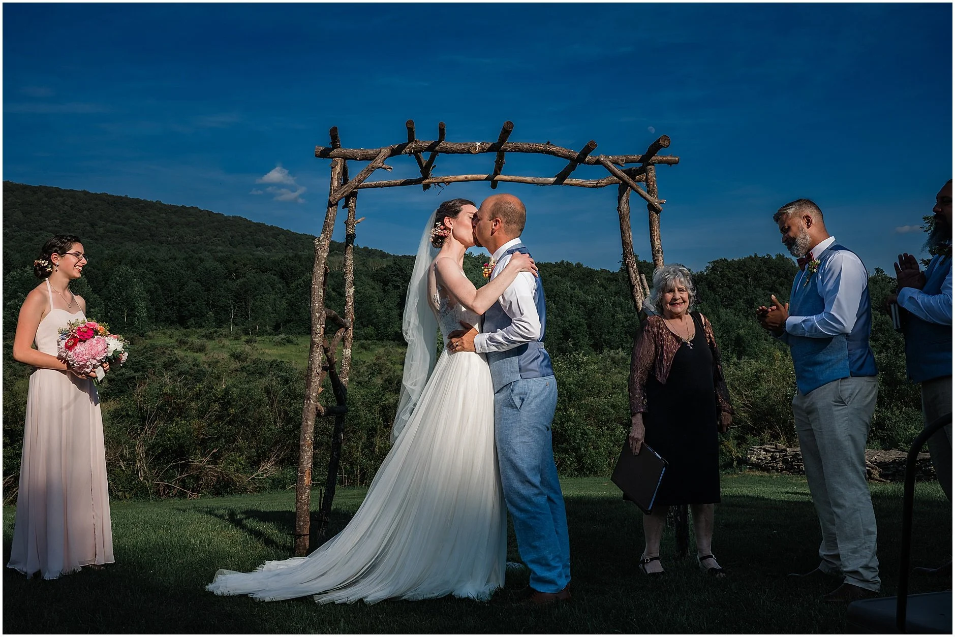 Bride and groom sharing their first kiss as husband and wife during their ceremony in the Catskill Mountains
