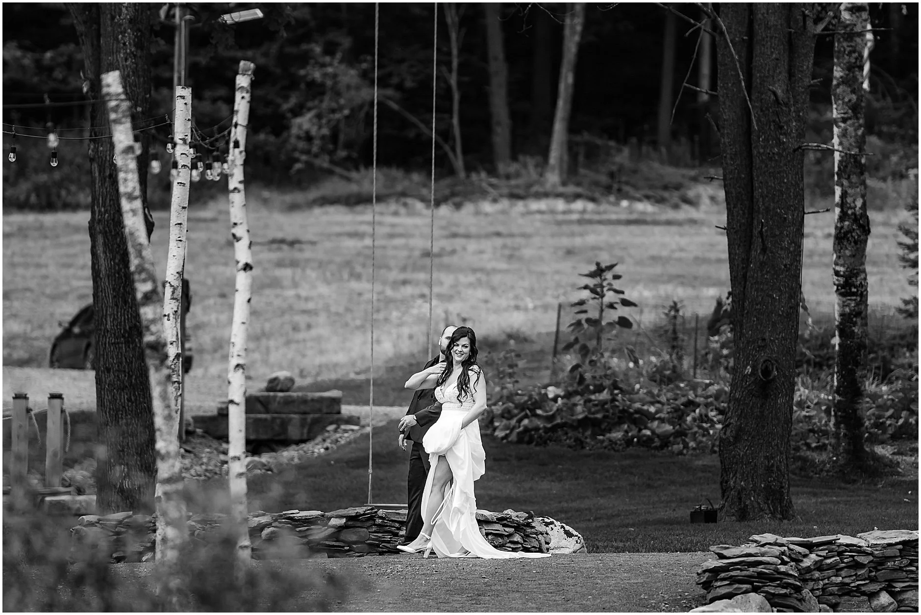 Black and white candid image of bride and groom walking together