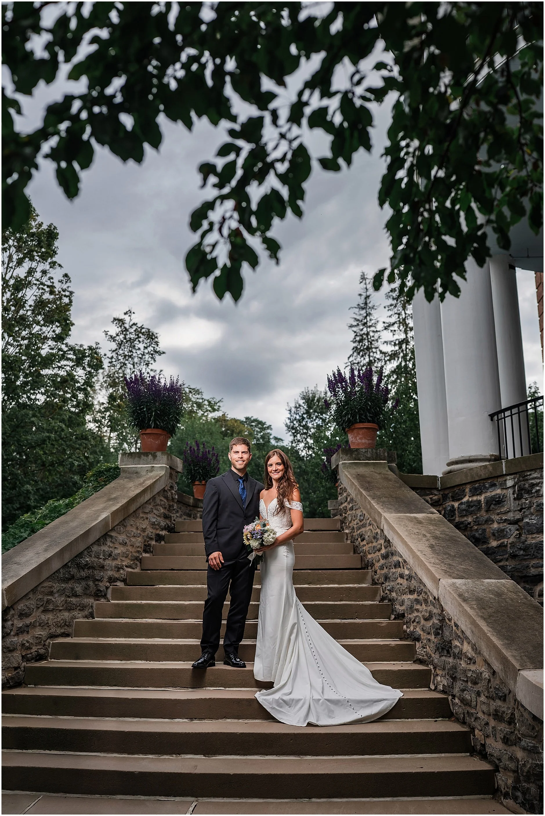 Bride and groom posing on the steps of The Otesaga for elegant portraits during a Cooperstown elopement.