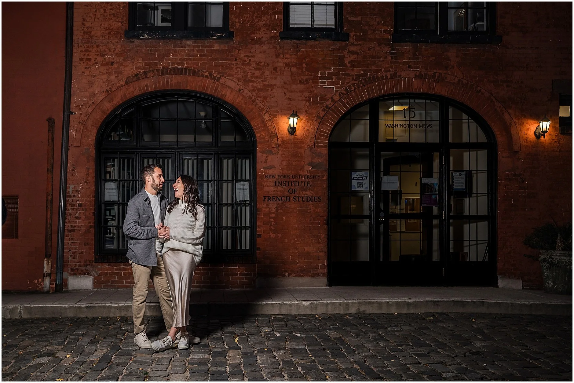 Romantic NYC engagement session on cobblestone street with brick building behind them