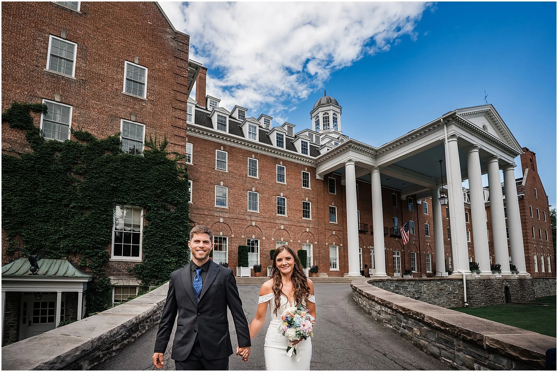 Couple walking together outside The Otesaga Resort Hotel during an intimate elopement in Cooperstown, New York.