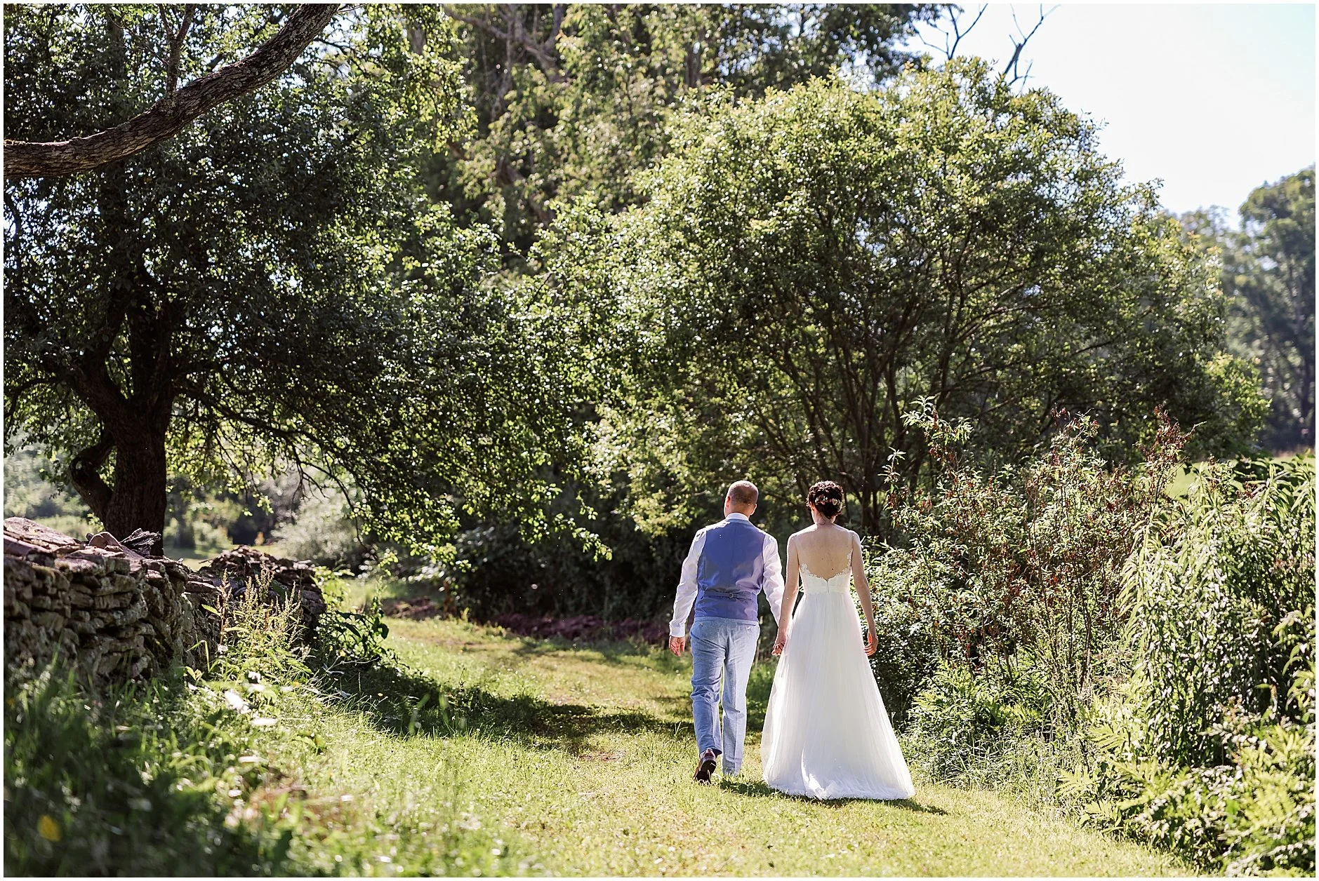 Newlyweds walking away from the camera hand in hand as they share a quiet moment in the Catskill Mountains
