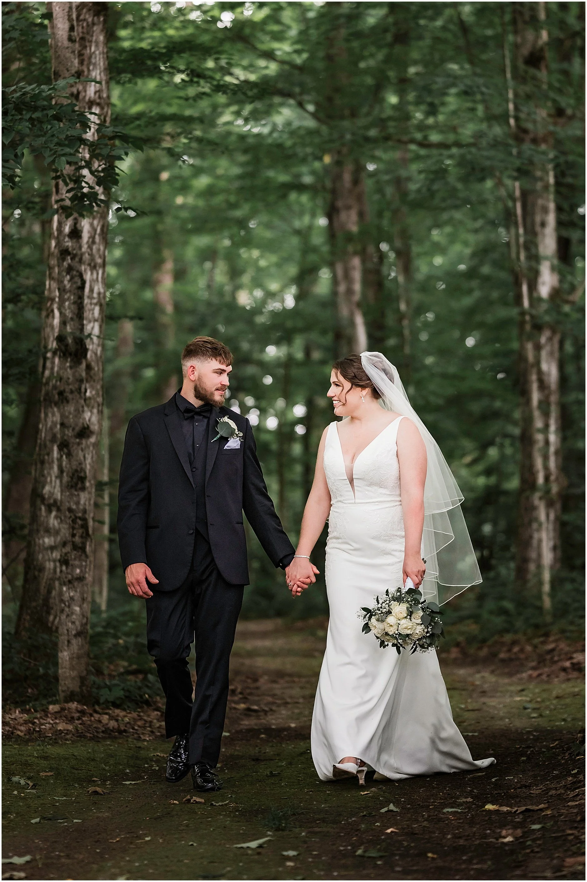 Bride and groom walking in the woods together after their spring wedding ceremony in the Catskills, NY.