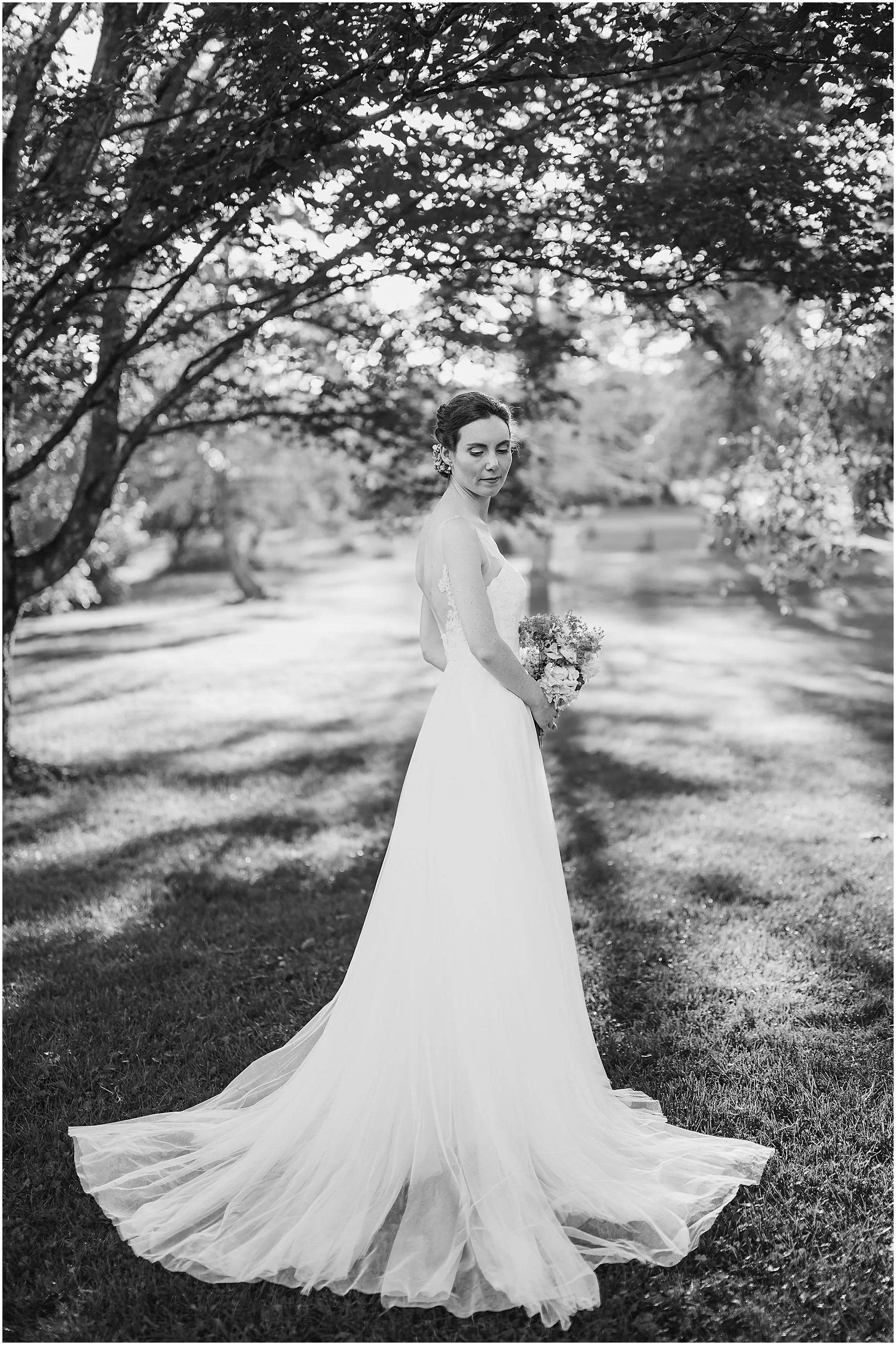 Elegant black and white portrait of the bride showing the back of her dress in Upstate New York