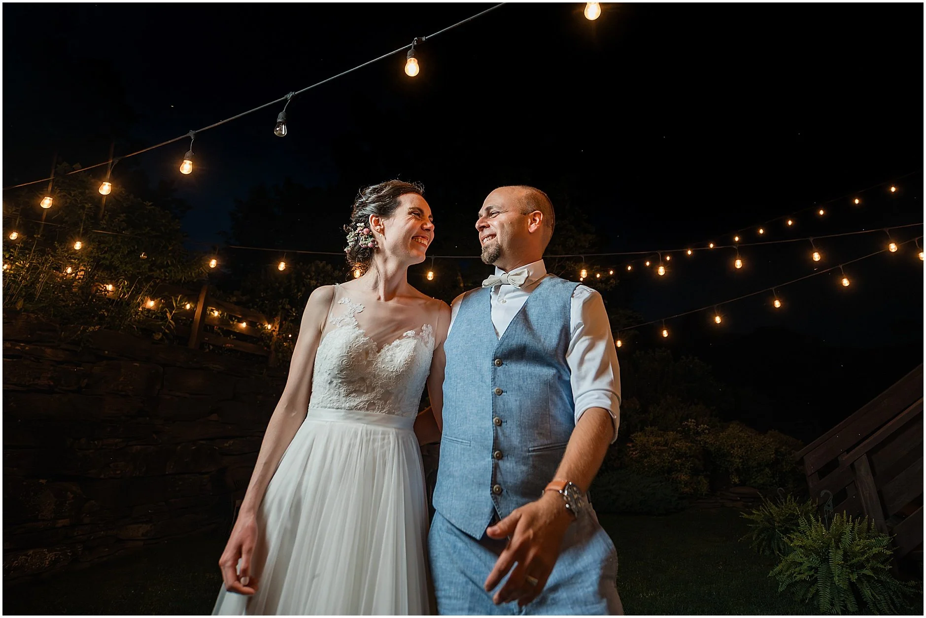 Bride and groom smiling big as they walk together under the stars of the Catskill Mountians