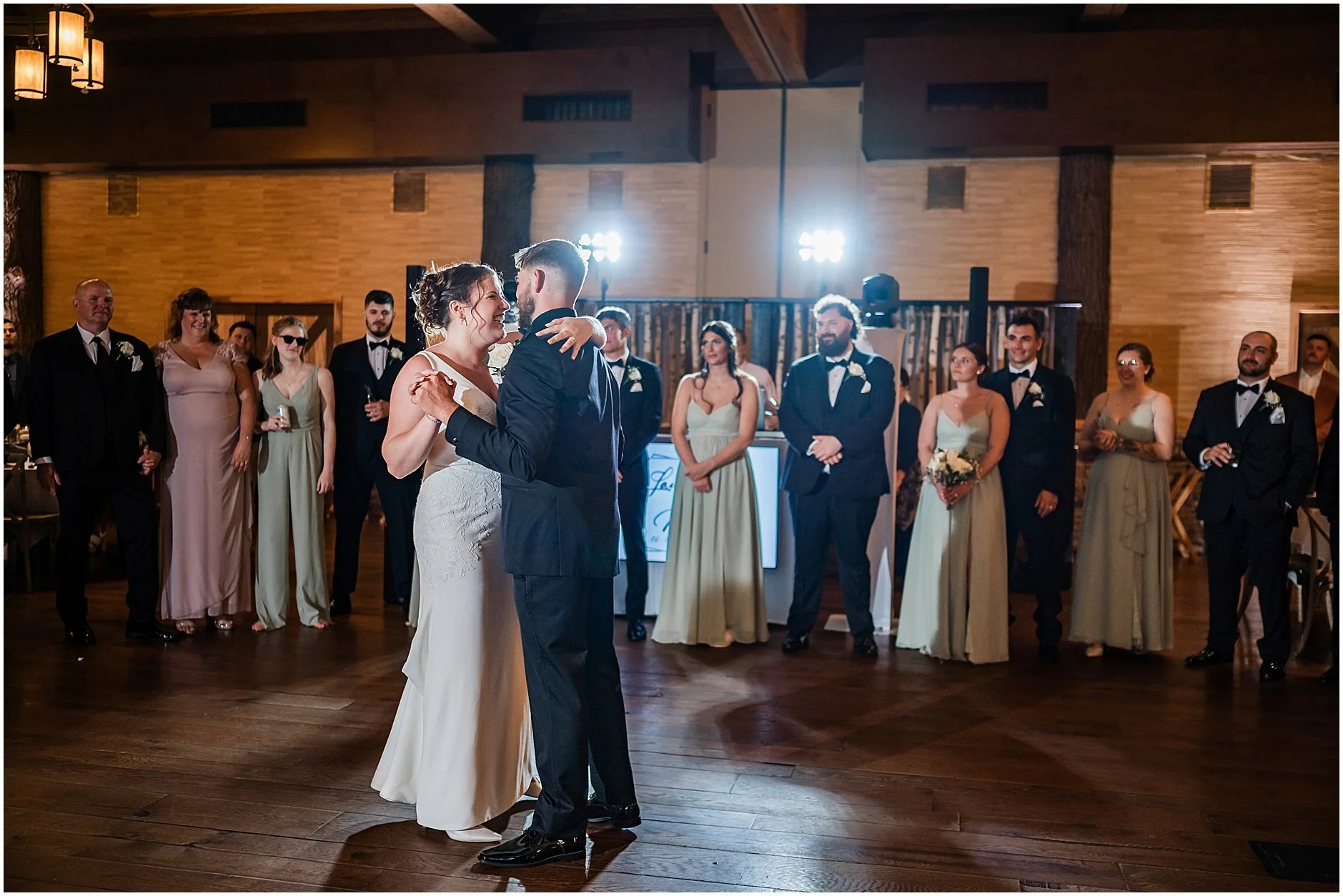 New York bride and groom sharing their first dance together with their loved ones in the background.