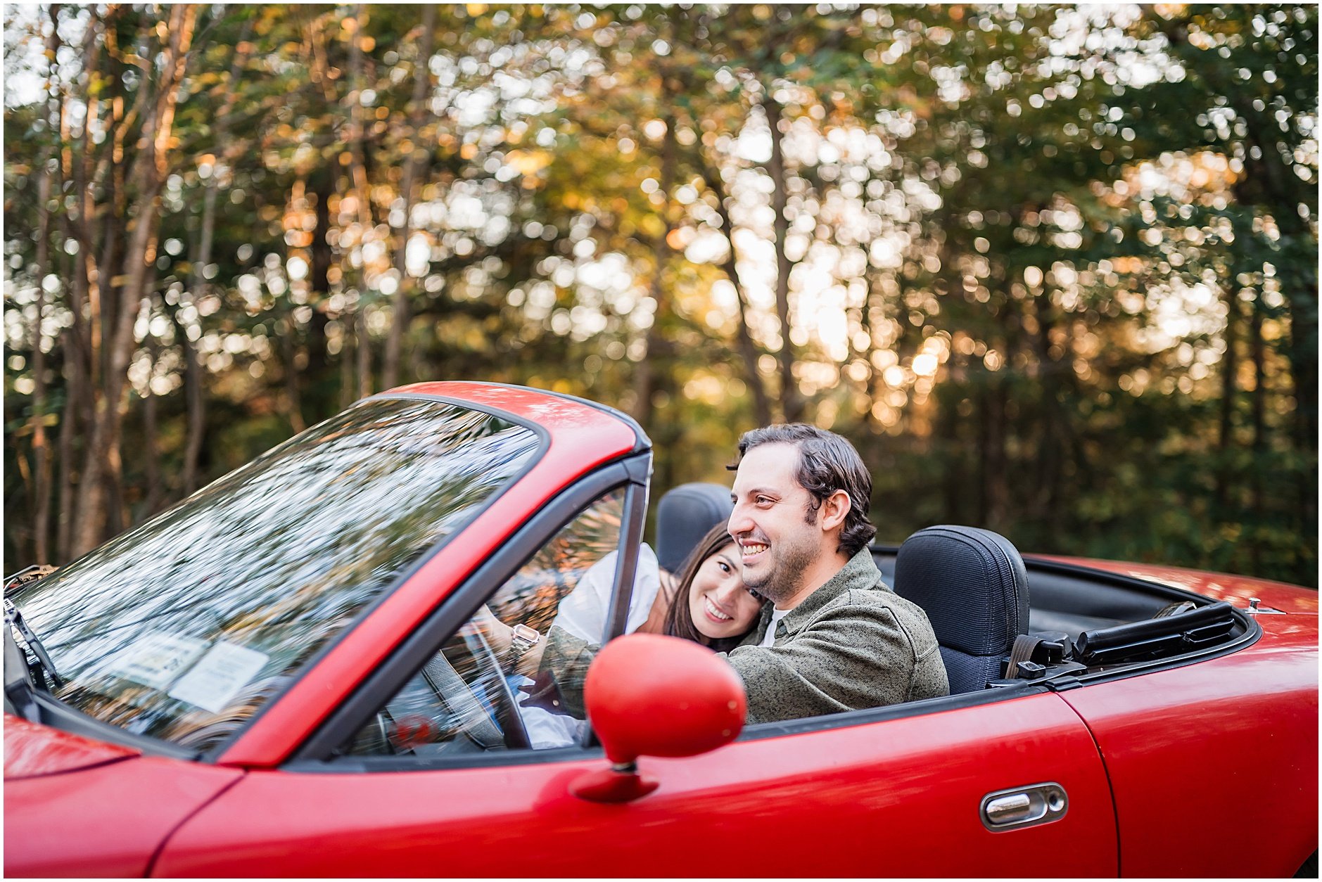 Playful engagement photo with vintage red convertible in Upstate New York