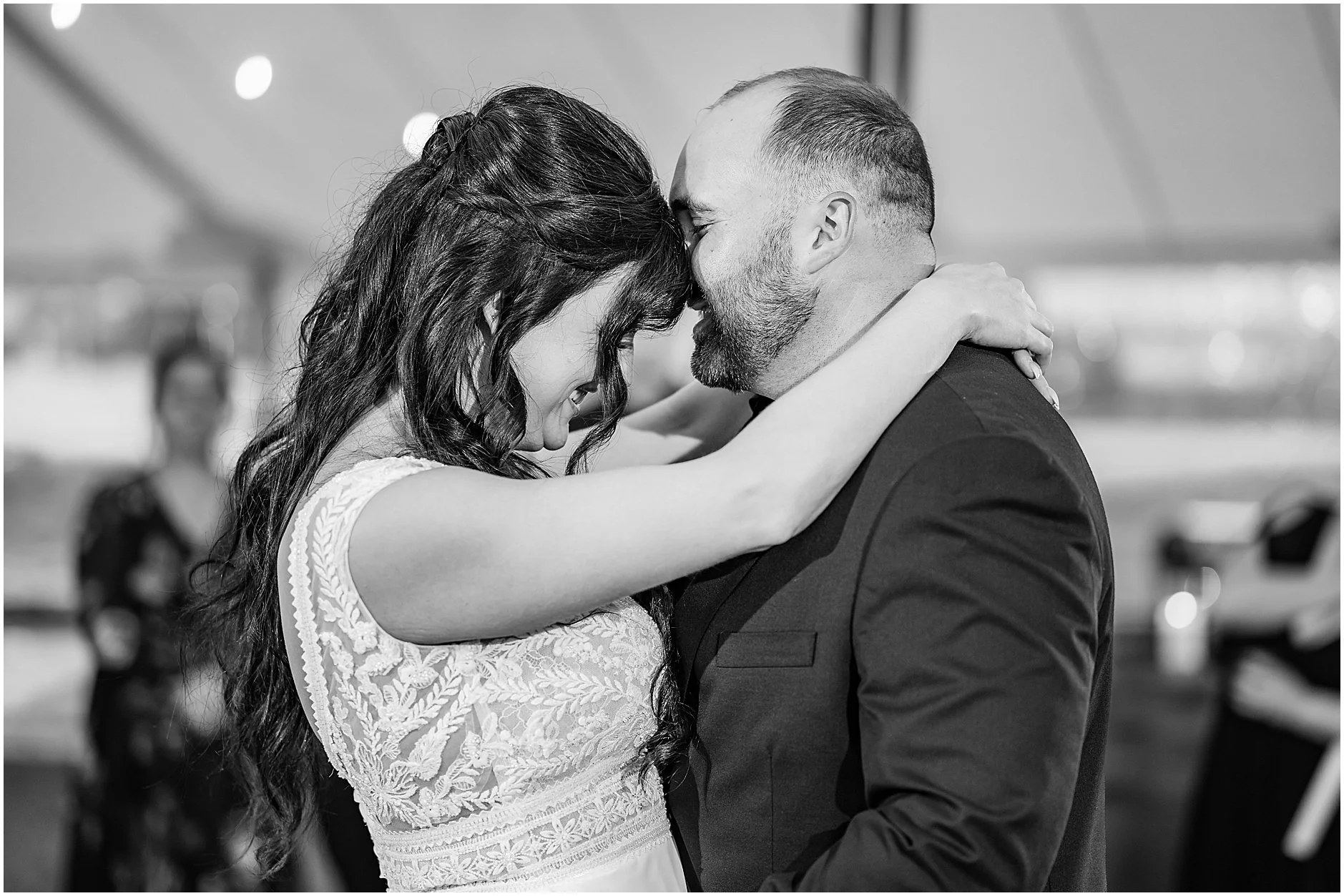 Black and white image of newlyweds dancing and laughing together