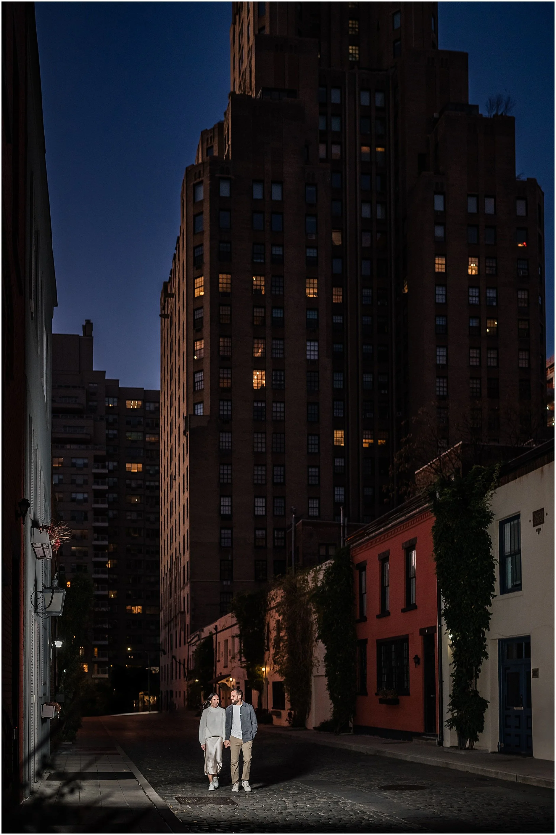 Couple walking down cobblestone street holding hands in Soho Manhattan during their NYC engagement sesison