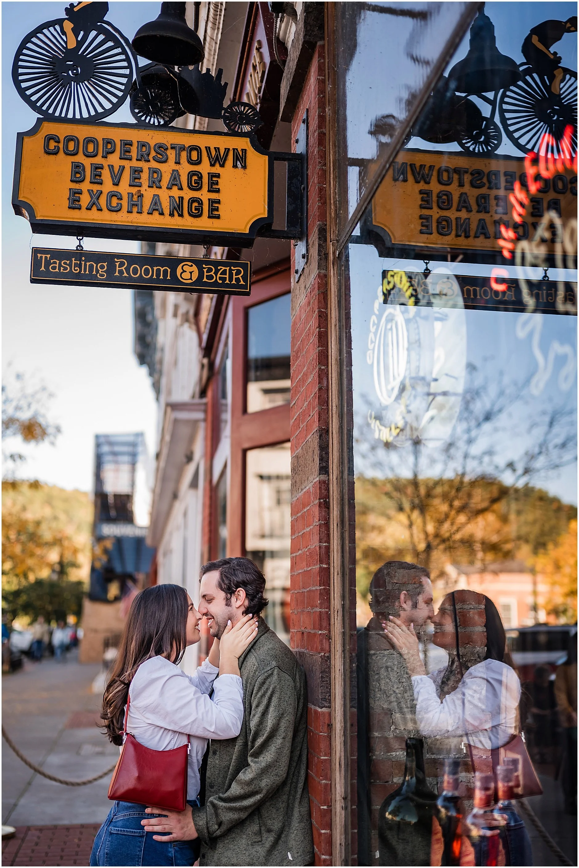 Joyful couple exploring downtown Cooperstown during fall engagement session