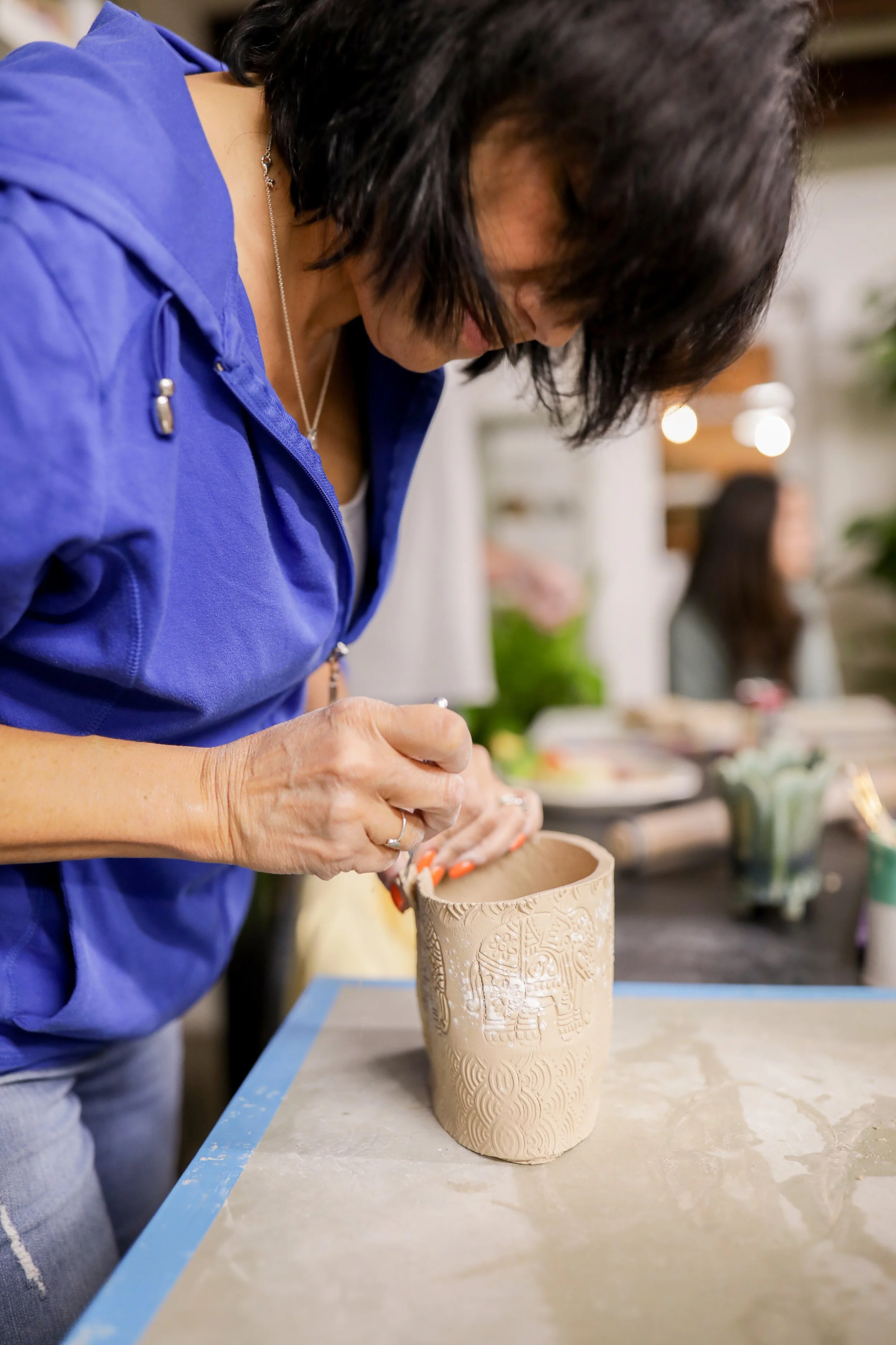 Student working on the rim of a piece at pottery workshop Point Pleasant, NJ