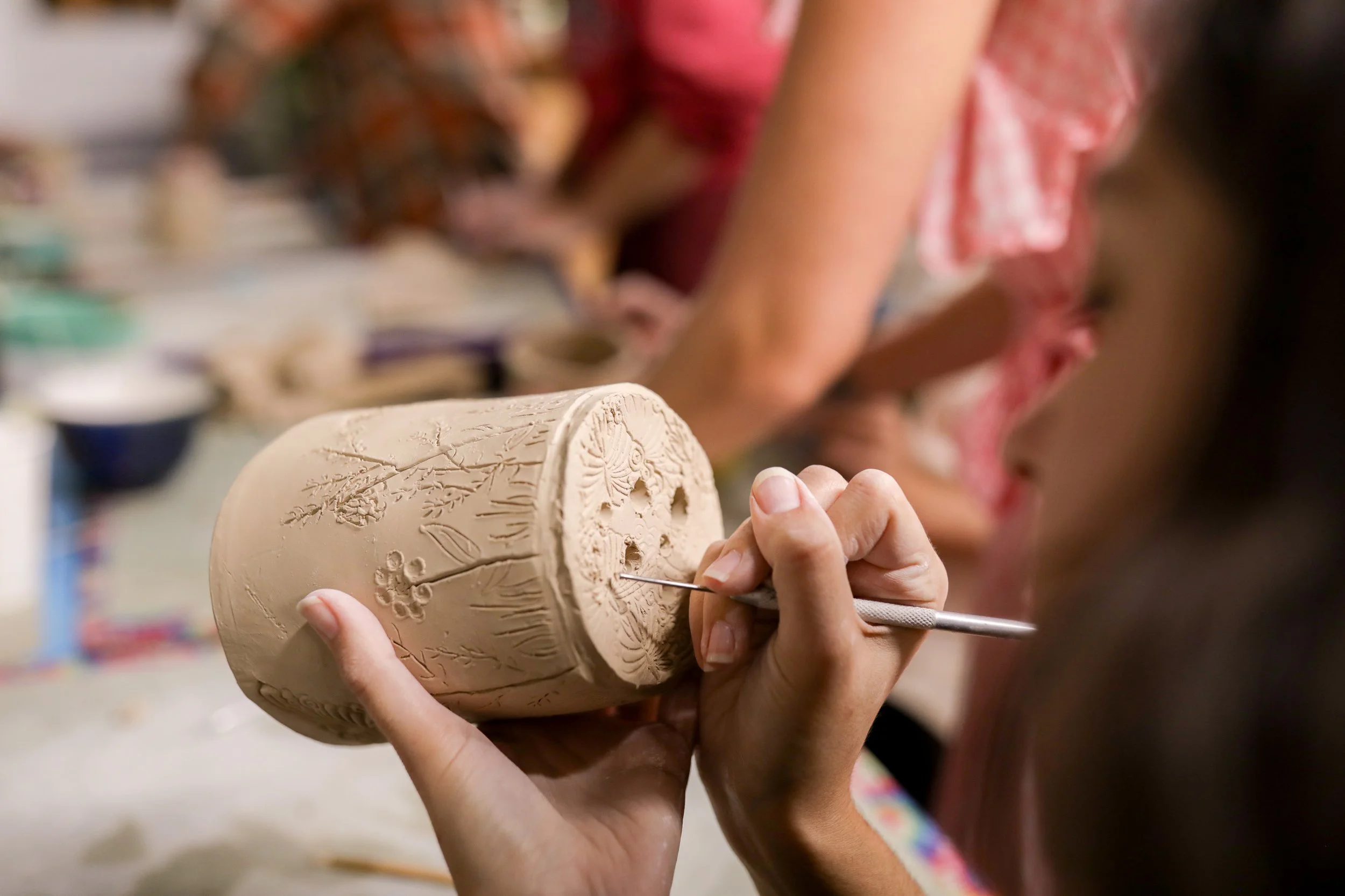 Students hand-building berry bowls at a beginner pottery workshop at District Refillery in Point Pleasant, New Jersey