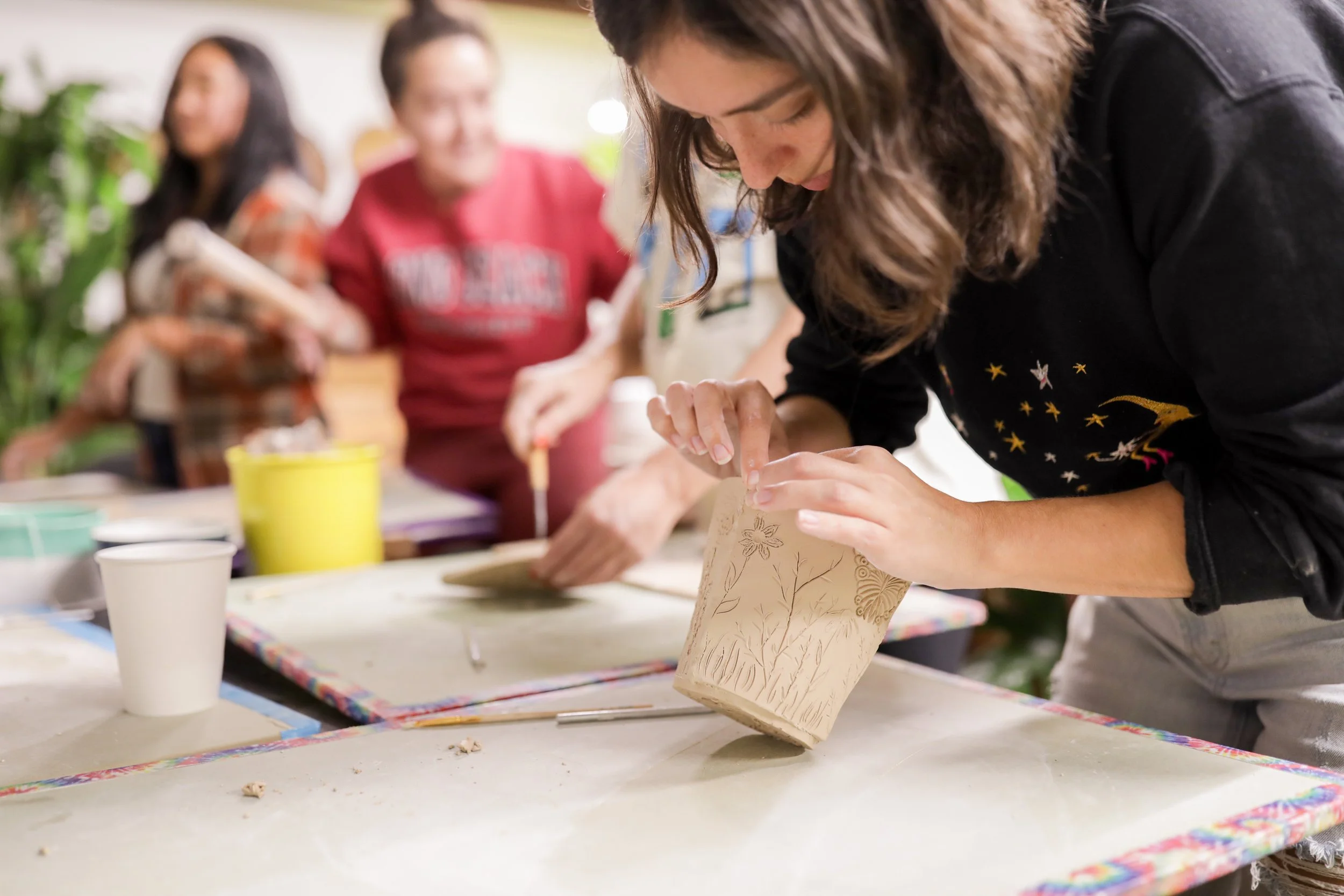 Clay slab being formed into a handbuilt vessel.