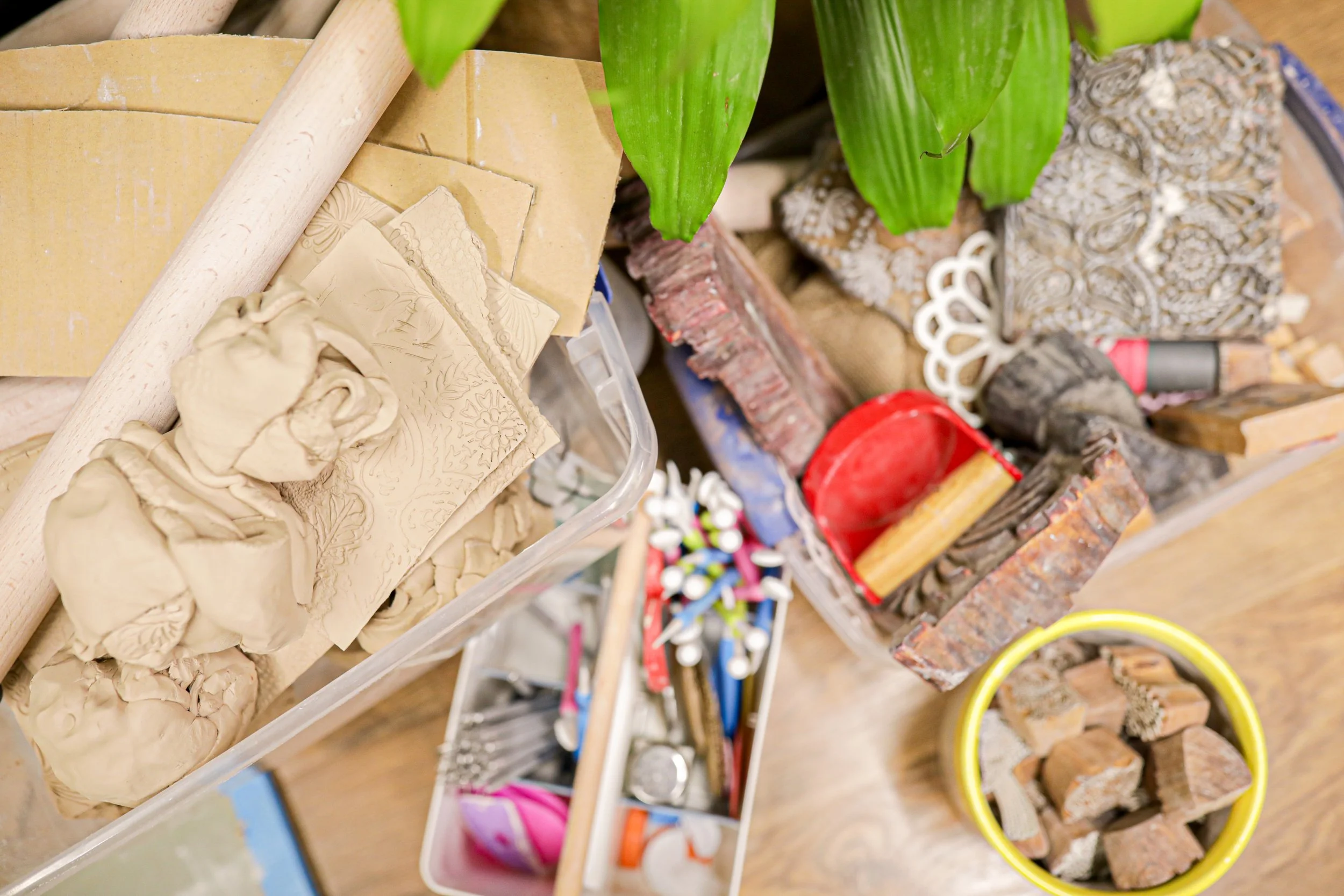 Clay and tools stacked in a bin for workshop setup