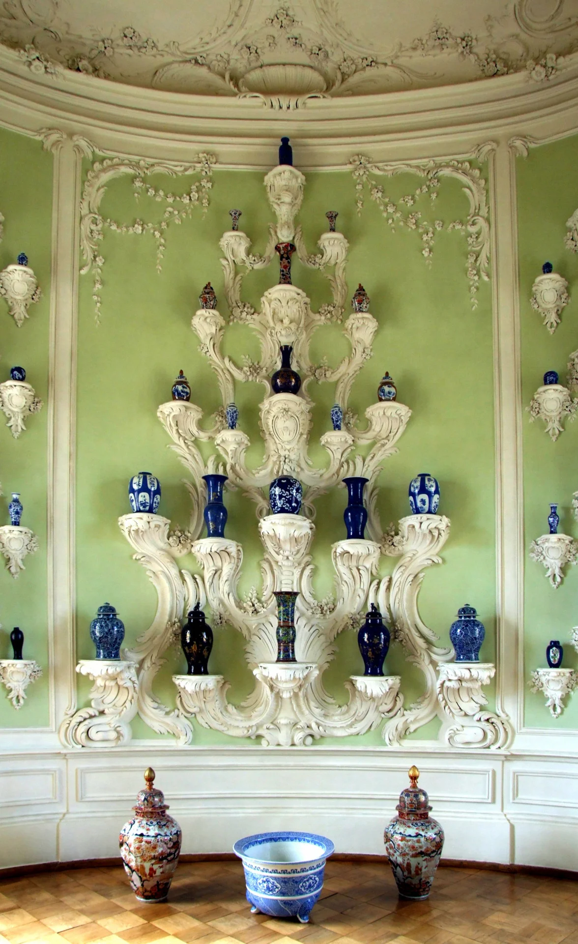 The Oval Porcelain Cabinet completes the staterooms. Forty-five rocaille consoles support a collection of Chinese and Japanese porcelain vases.