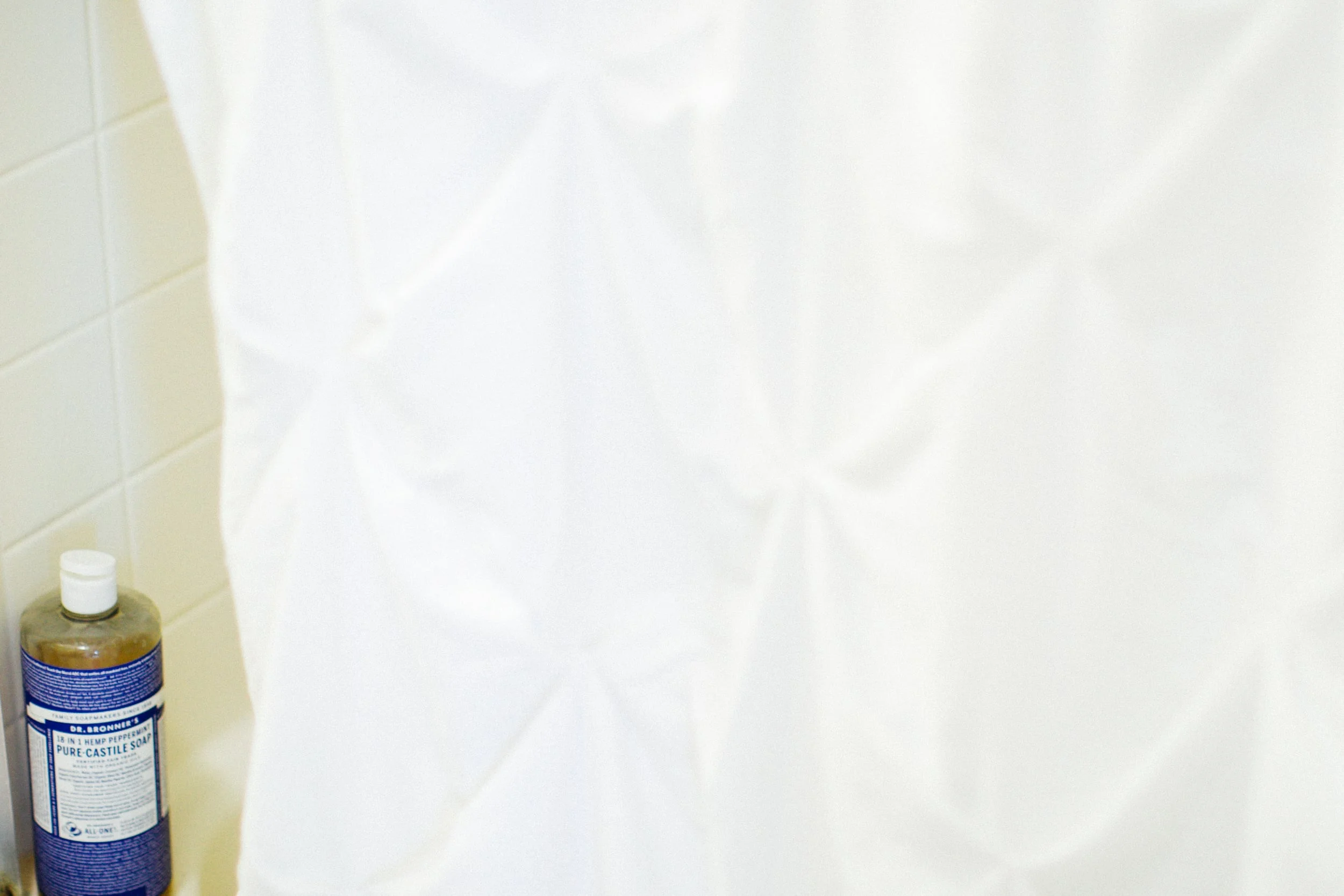 My absolute favorite body wash peeking out behind our shower curtain! It's organic and totally natural and can be used for 18 things! including cleaning -- i actually mop the floors with it because it's safe for pregnancy, gets them totally clean, and smells so pepperminty -- made with pure essential oils! 