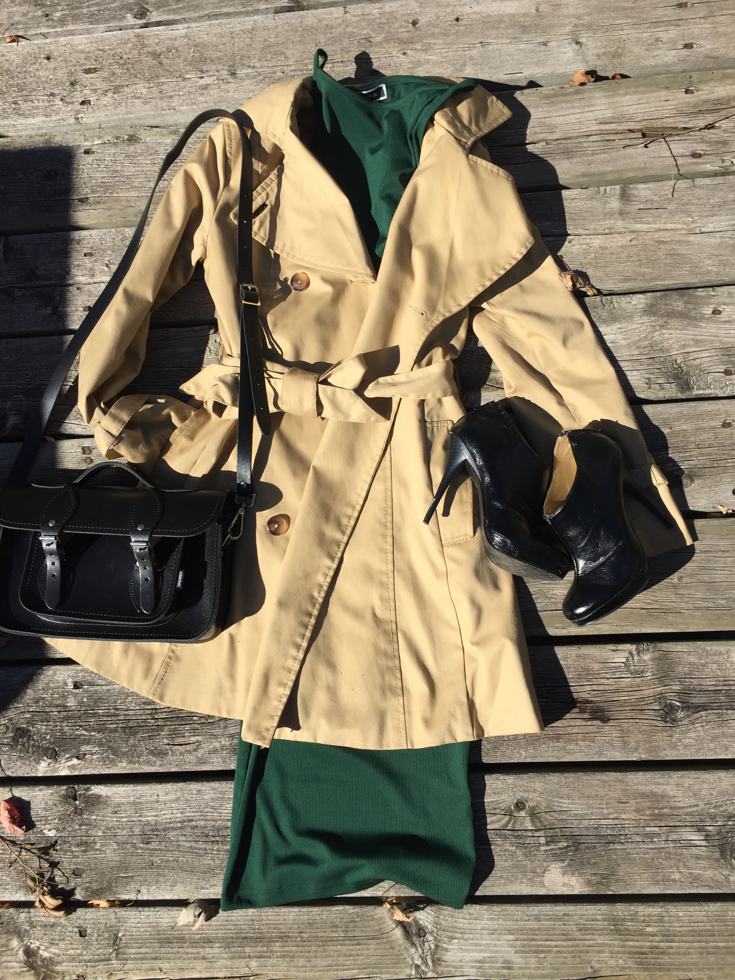 Green midi dress with flared  tan trench coat, black booties and black hand bag