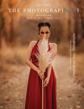 Woman in a red dress standing outdoors in an autumn setting, holding a large pampas grass arrangement.