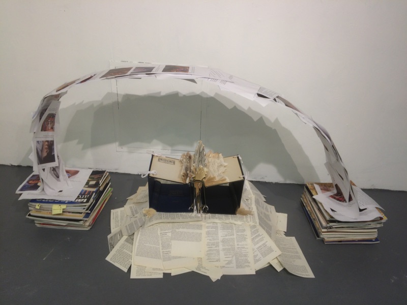 "Judging Student Progress" (2016). Materials: 1920s textbooks, found student report on Playboy, stacked art critique magazines.