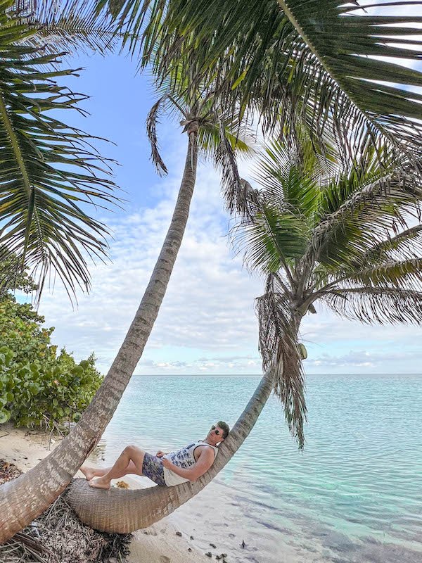 Belize - resort Belize Dive Haven - Turneffe Island Resort - Adam Relaxing on Palm Tree.jpg