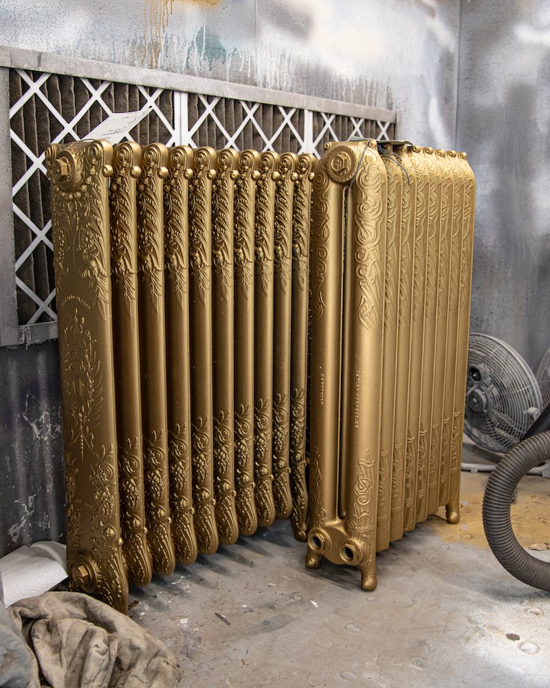 Two ornate cast iron radiators in the paint booth at Ironworks Radiator Inc