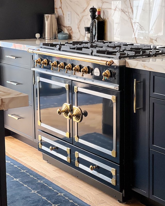 Toronto home renovations - renovating a victorian home - kitchen renovations - calacatta gold porcelain countertop and backsplash with navy slim shaker cabinets and navy la cornue range with brass knobs - la cornue kitchens.jpg