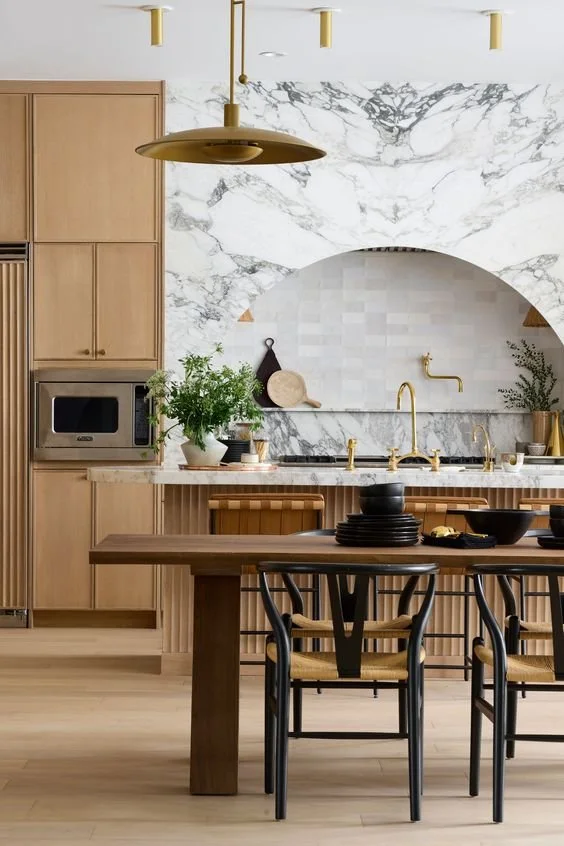 2024 kitchen trends - natural wood cabinetry with marble arched kitchen range hood featuring zelliga tile backsplash and reeded island detail - (Image credit- Erick Kruk. Design - Cdot Design Studio