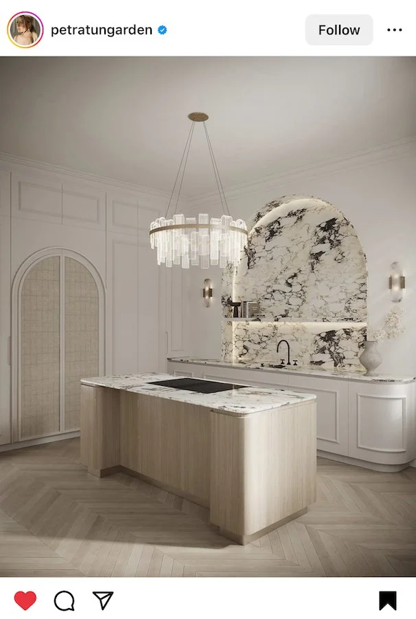 2023 Kitchen Trends - Beautiful creamy kitchen with arched marble backsplast, statement lighting chandeliere and light cheveron floors