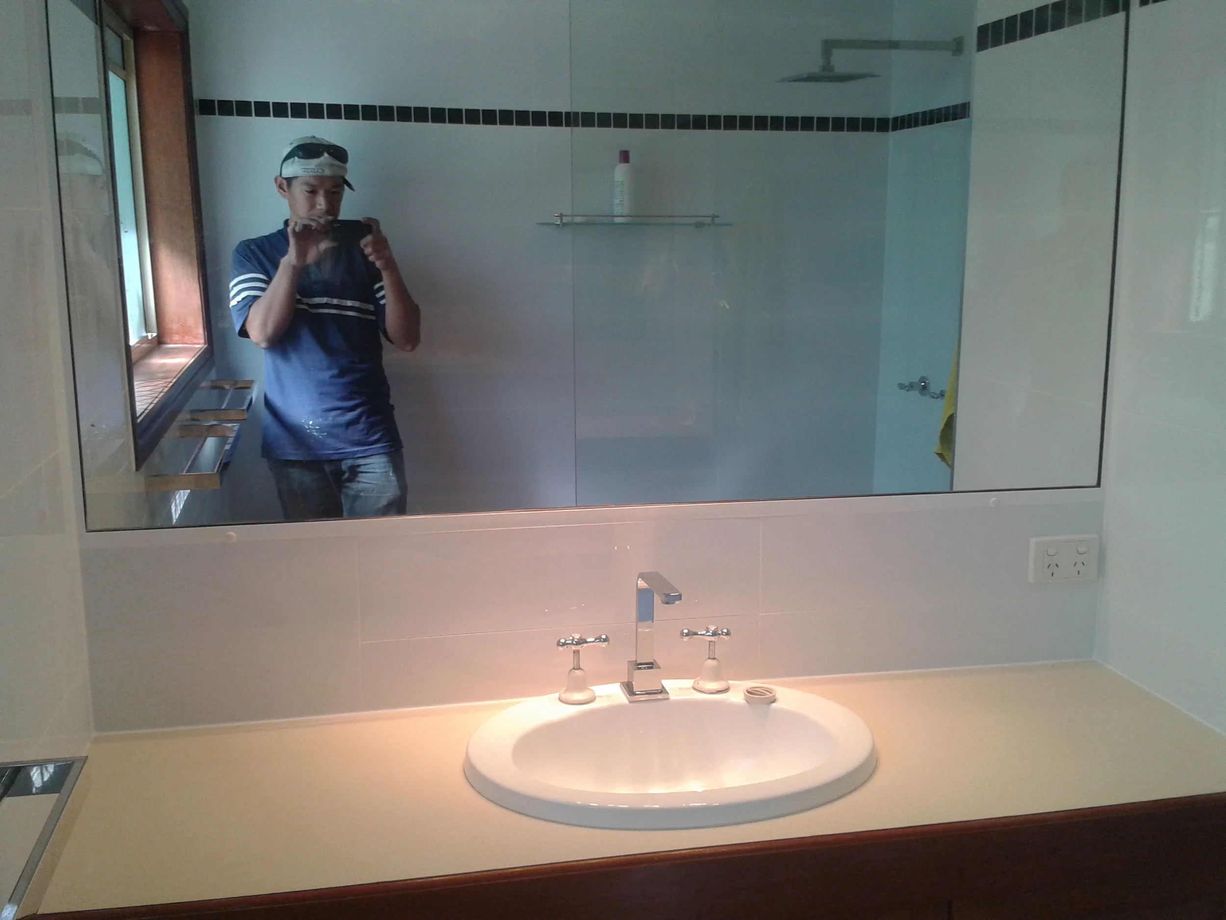 As the homeowner didn't want to fork out a few extra grand to get a new custom vanity to fit this space all we did here was replace the taps and added a light above the mirror. It still turned out superbly. And that's me. Can I help with your