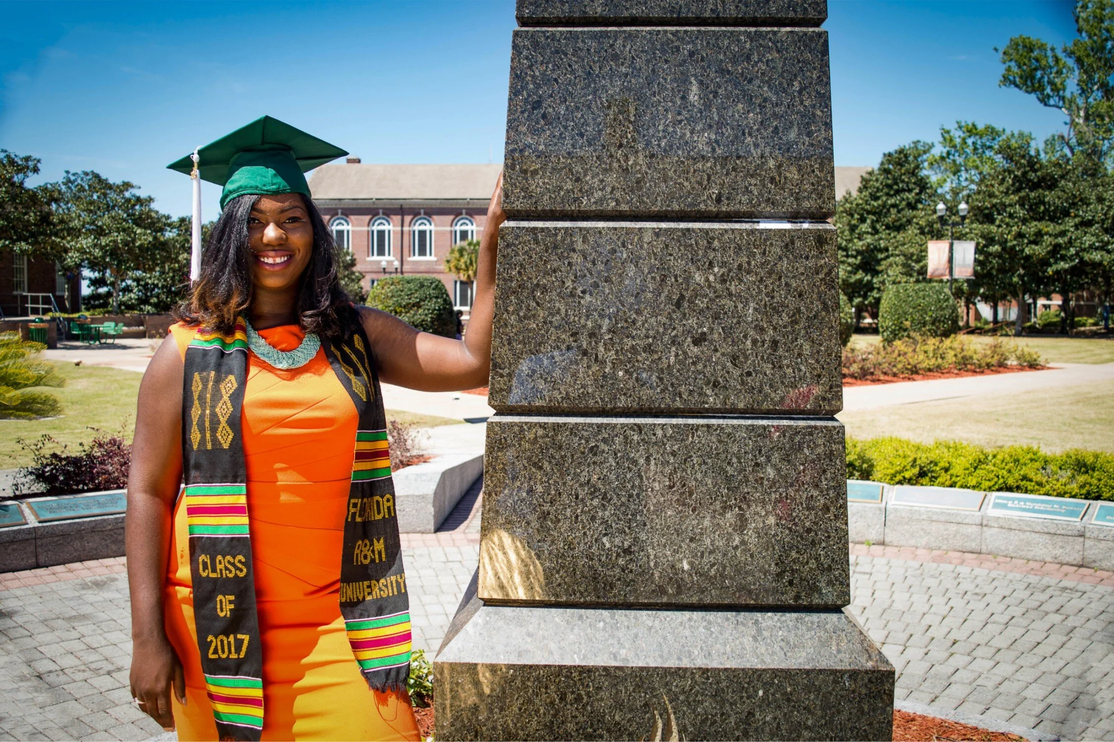  FAMU graduate Shaperlya in an orange dress at the Eternal Flame 