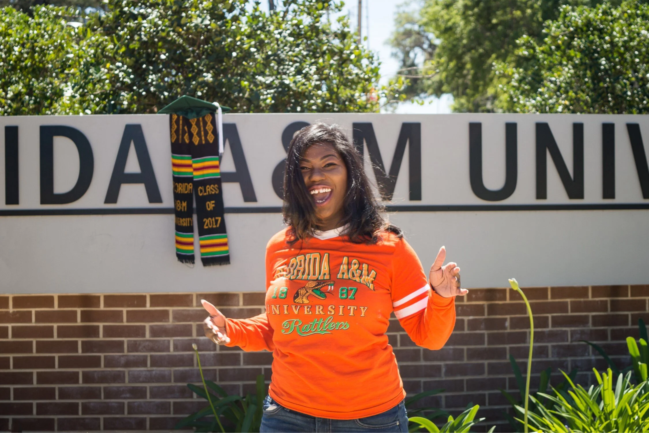  Graduate Shaperlya dancing in front of new FAMU roundabout in a casual university tshirt and jeans. 