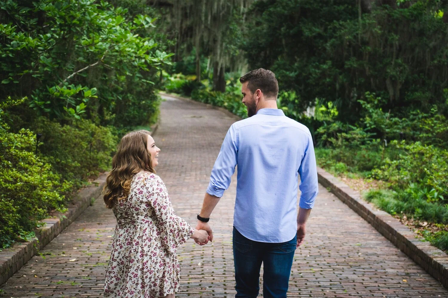 Man and woman holding hands and gazing lovingly at each other during their engagement photo session
