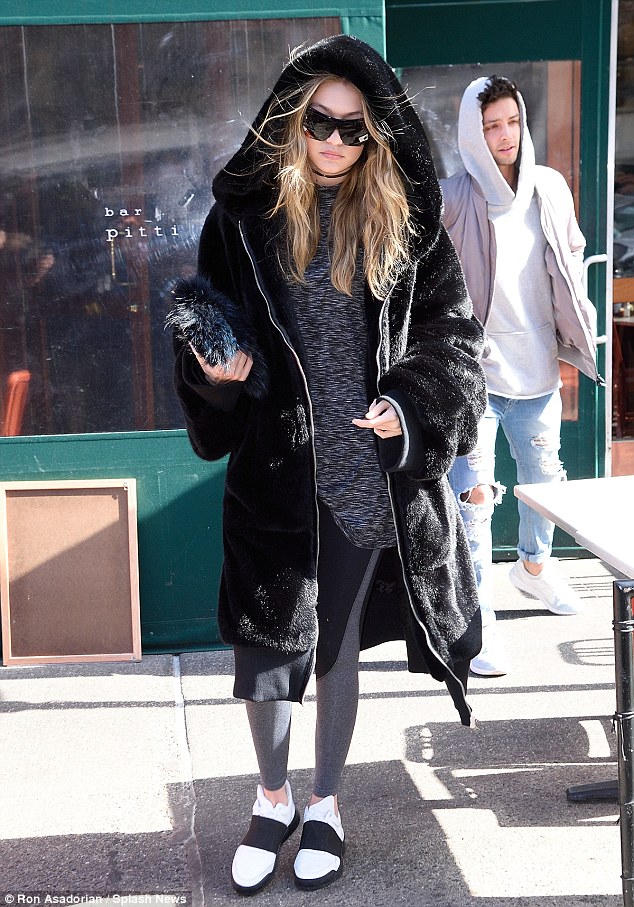 Gigi Hadid was spotted wearing a mink coat, yoga pants, and a pair of Low Top Elastic White sneakers by Filling Pieces.