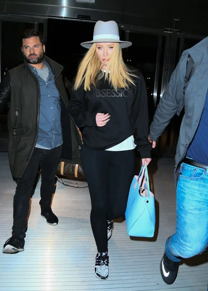 Iggy Azalea made her way through JFK touting a Dior Addict Shopping Tote , a Calvin Klein Obsession Sweatshirt and a pair of adidas Ultra Boost Reflective Sneakers. 