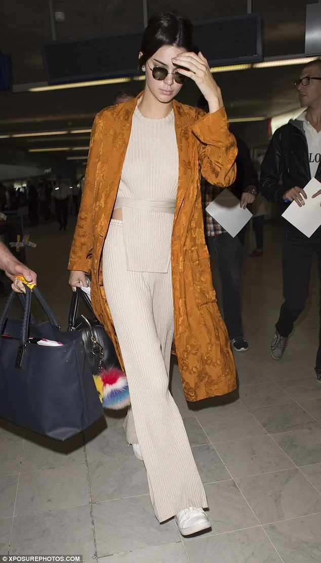 Kendall Jenner, always the sneaker style star, looked stylish in a kimono-style coat, a knitted tabard top and loose-fitting trousers by Elle Sasson, and a pair of her favorite Kenneth Cole 'Kam' Sneakers.
