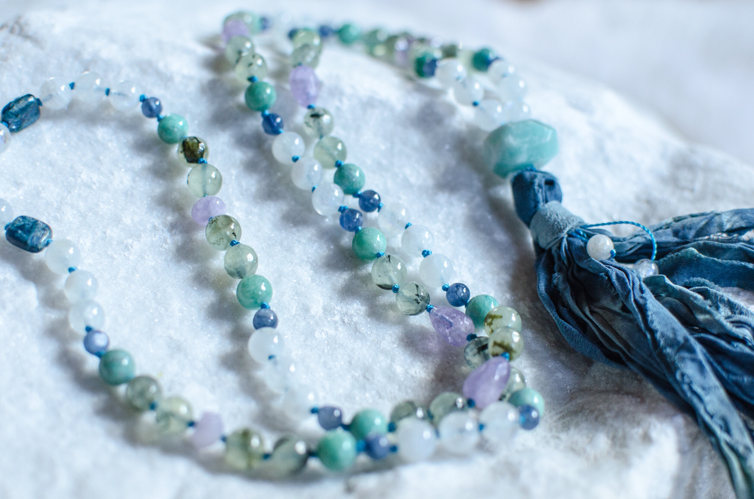 Amazonite. Moonstone. Kyanite. Prhenite. Amethyst. Love. Indigo Plant Dyed Tassel. Mantra: OM SO HUM ~ I AM. That. May I be a force of cooling nourishment within a world of heat and pressure. I am Home within the storm. A blessing for these changing times. Drink me in and I will re-vitalize you... I am clarity, descending in action.