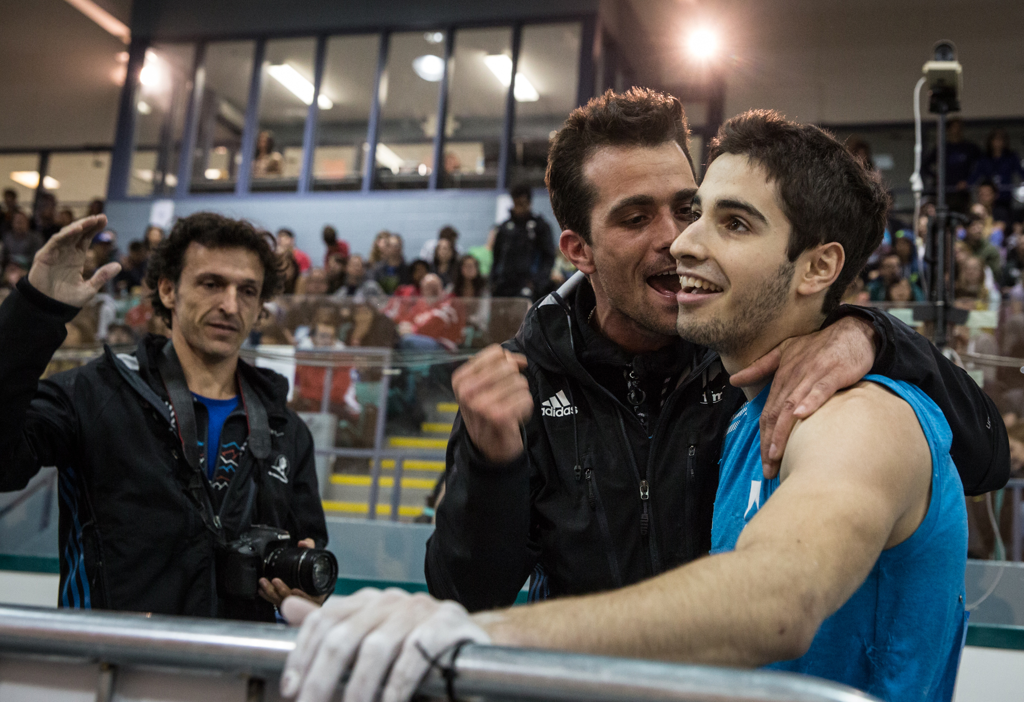 Alban Levier, French climber, tops the final problem, and his coach congratulates him at the end of the competition.