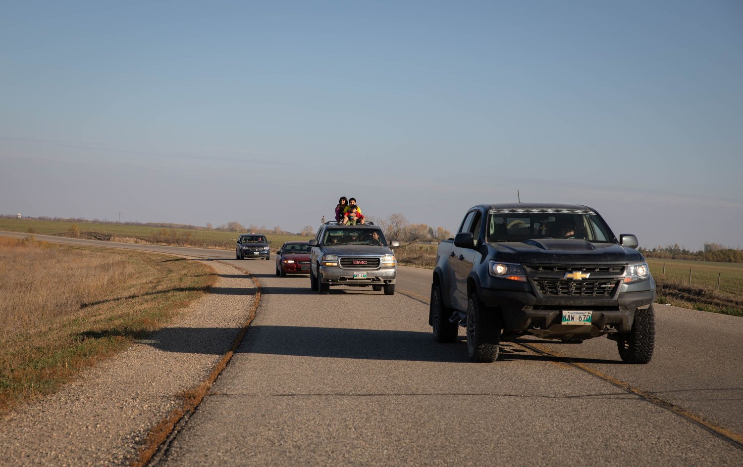  Children of nearby Birdtail Sioux Dakota Nation watch the riders atop a car while following the group during the final hour of the ride. 