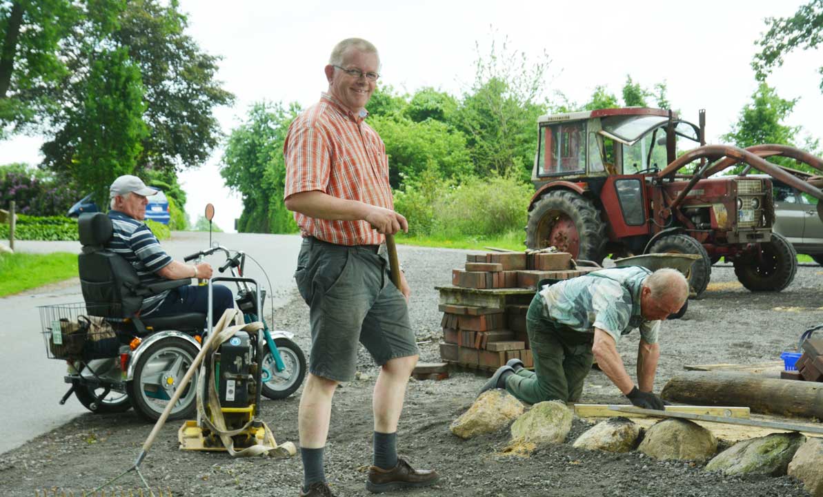 Findlinge stützen die Pflasterung an dem abschüssigen Gelände an der Hütte in der Krevinghausener Schweiz.