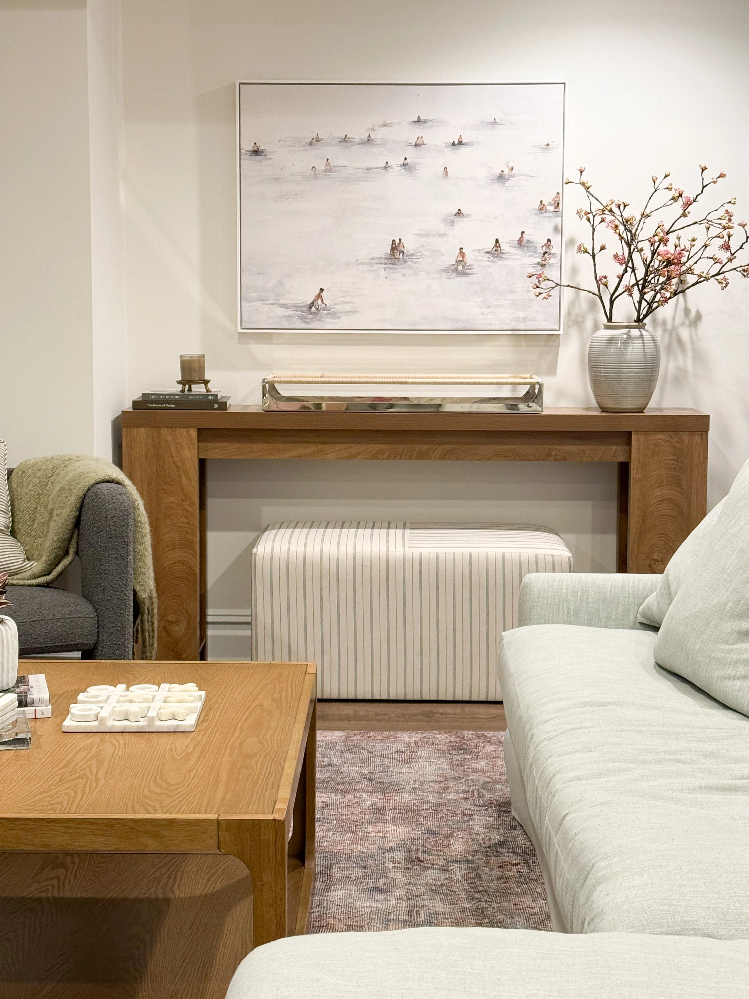 basement console table styling, oversized framed artwork, neutral basement wall decor, Minted wall art, warm wood console table, coastal basement decor, basement seating area, soft neutral interiors, basement design inspiration, modern organic decor