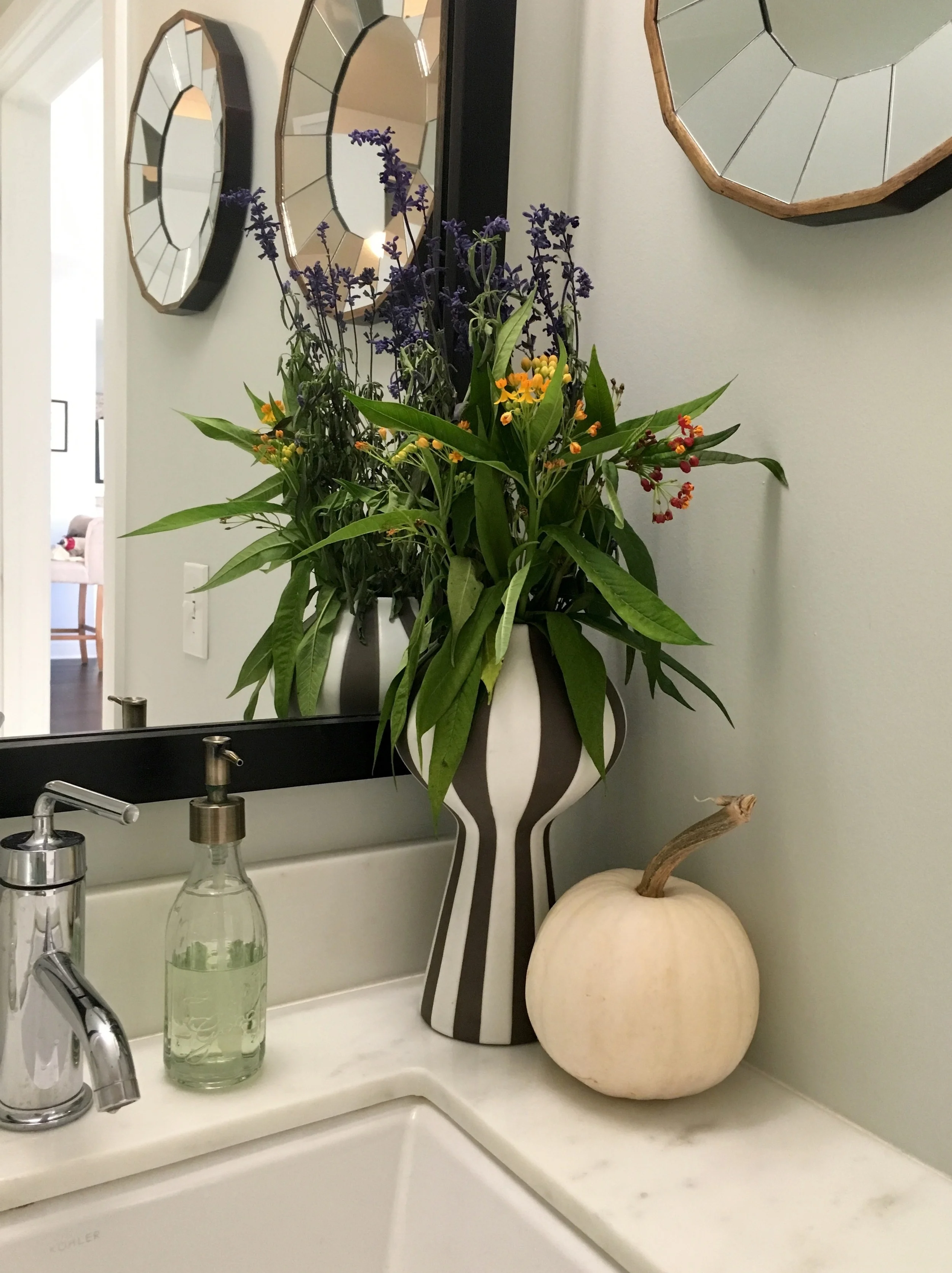 Rustic flowers and pumpkins in the guest bath.