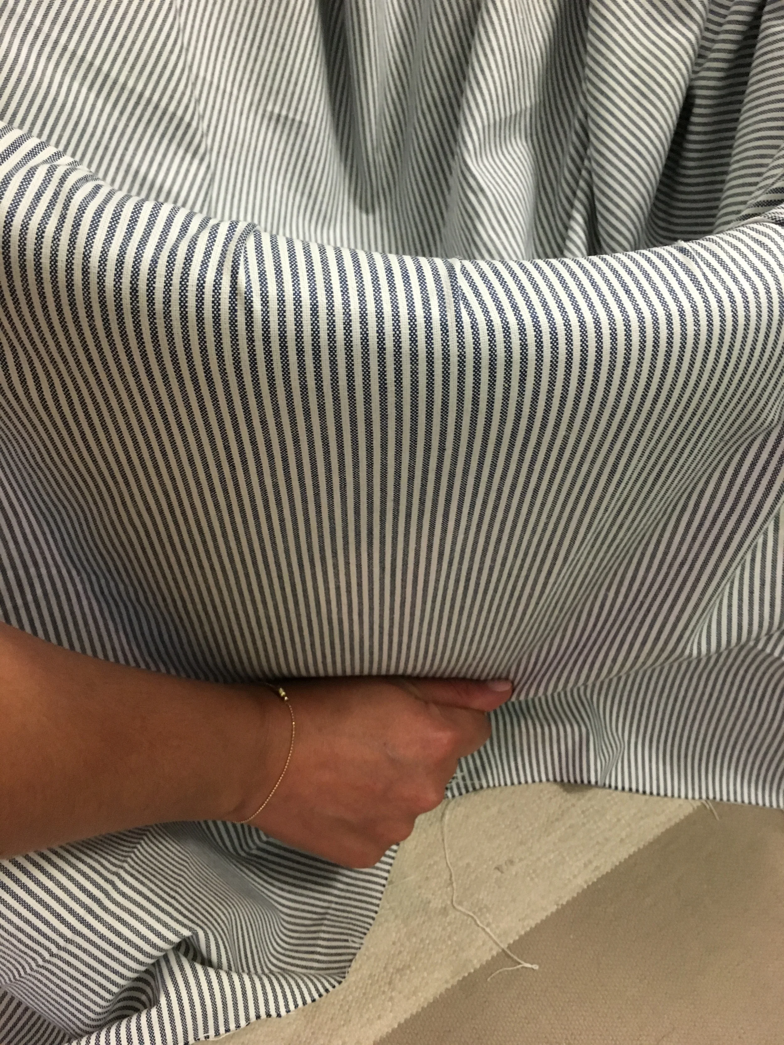 Once stapled from the inside, I folded the fabric over the top and pulled tightly around the side before stapling it to the bottom of the ottoman.