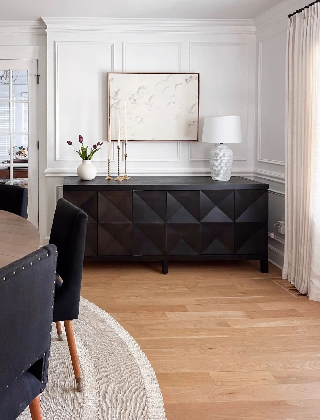Love this dining room! We went with the prettiest natural fiber rug to ground the space and pops of black keep it neutral but still interesting. You might recognize this framed canvas from my own home (It&rsquo;s hanging in our guest bedroom!) 

Comm